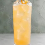 Коктейль Оранж Фіз (Jägermeister Orange Fizz) у хайболі з льодом і апельсиновою цедрою