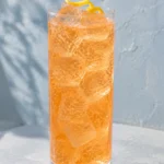Коктейль Єгермейстер Оранж зі спрайтом (Jägermeister Orange Lemon-Lime Soda) у хайболі з льодом і лимонною цедрою