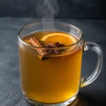 Коктейль Безалкогольний пунш (Non-Alcoholic Punch) у термостійкому келиху з паличкою кориці, бадьяном і скибочкою апельсина